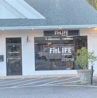 FitLIFE Charleston storefront, with white siding, a dark sign and FitLIFE lettering on the window.
